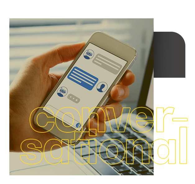 Uma pessoa está segurando um celular na frente de um laptop. conversational
