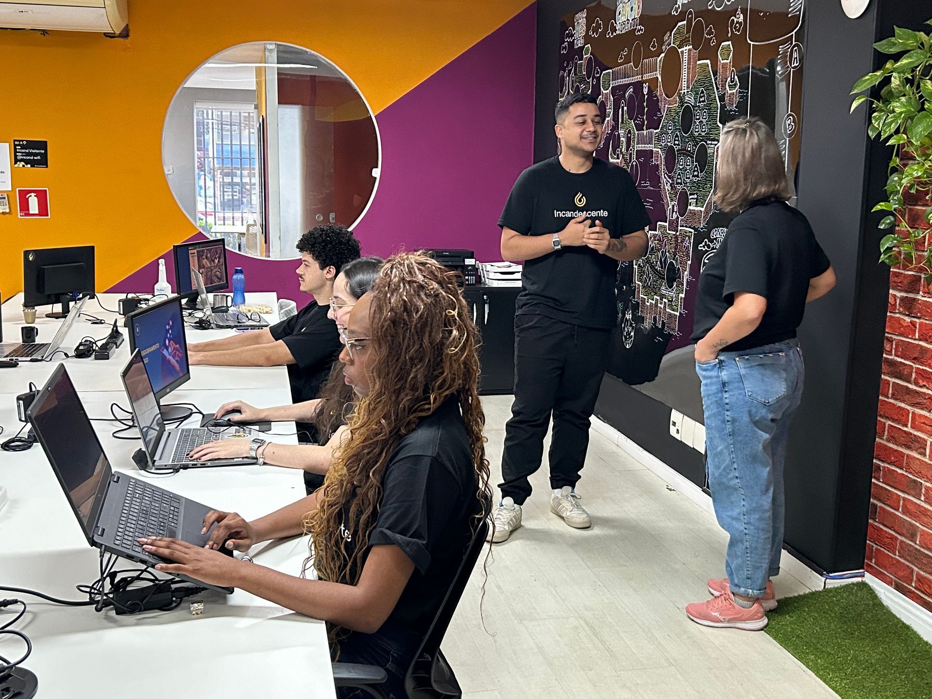 Um grupo de pessoas está trabalhando em laptops em um escritório.