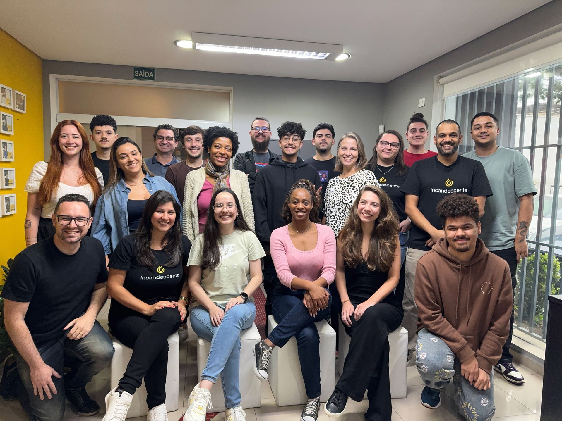 Um grupo de pessoas está posando para uma foto em uma sala.