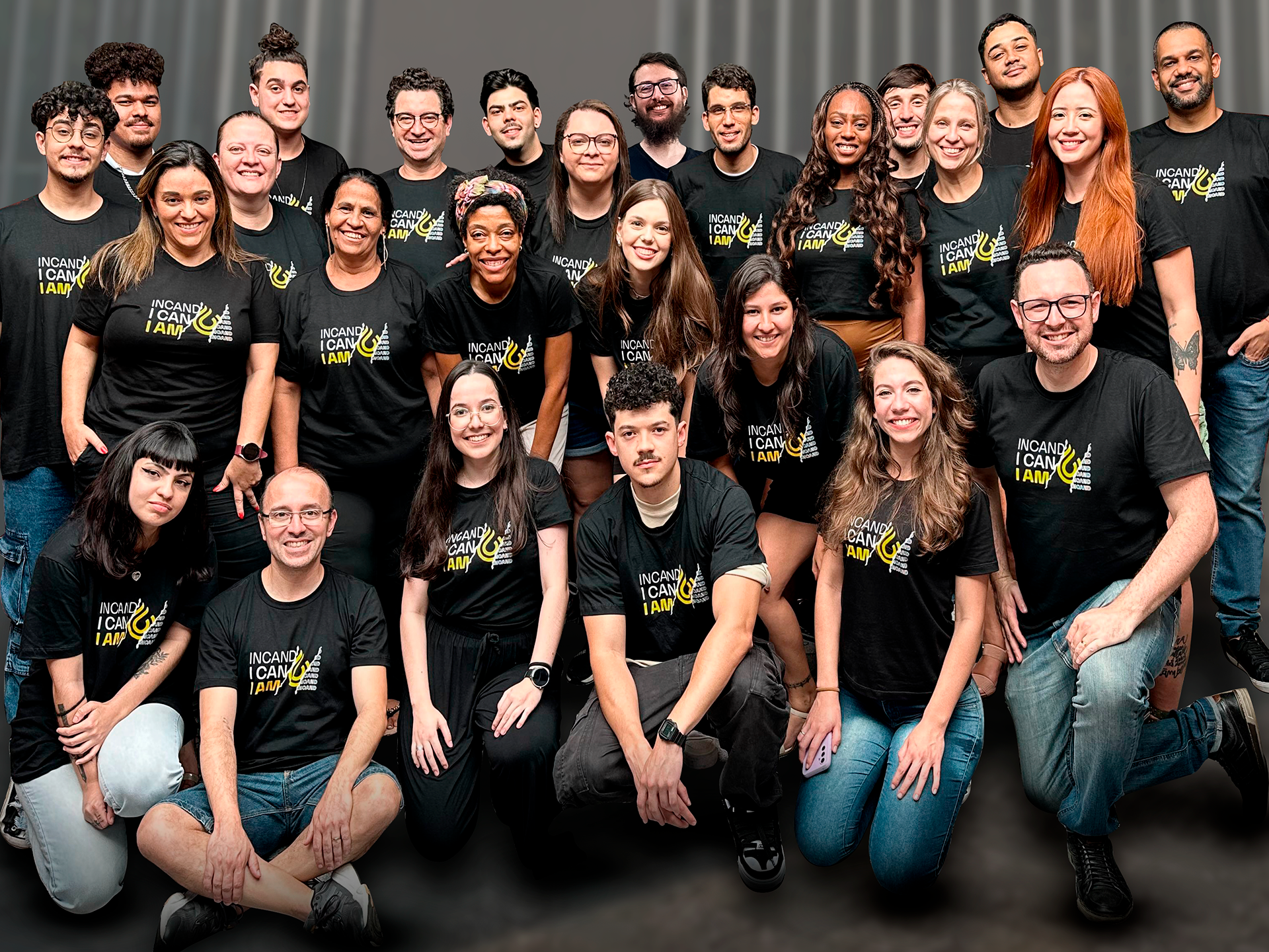 Um grupo de pessoas está posando para uma foto em uma sala.